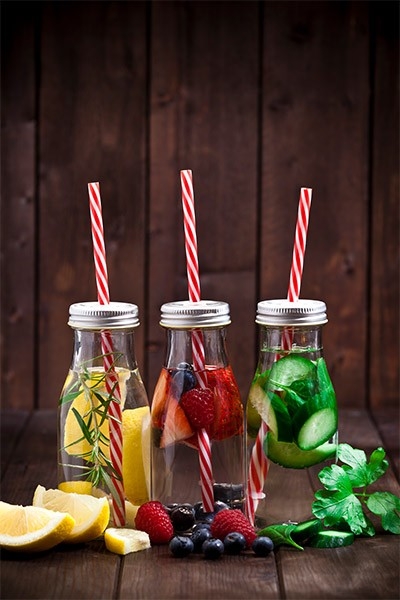 Deux verres remplis d’eau et agrémentés de rondelles de citron et de menthe: rafraîchissante et sans sucre, une boisson idéale pour l’été!