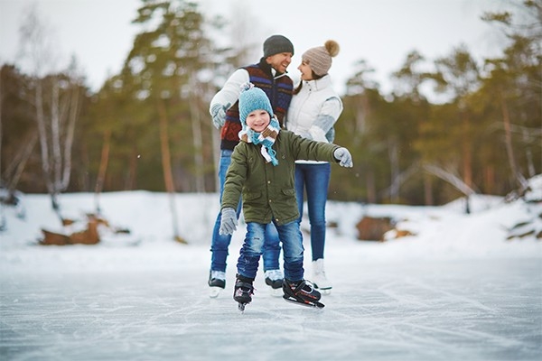 Una famiglia pattina sul ghiaccio. Fare moto all’aperto aiuta a restare in forma anche durante le festività.