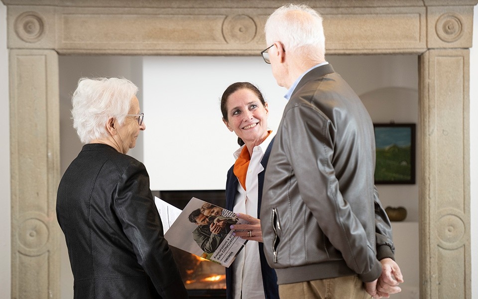Maria Colombina Moratti parla con una coppia di anziani nel suo ufficio a Stabio